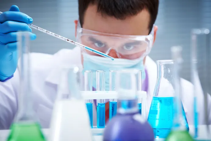 Profesional de laboratorio pipeteando una muestra en tubos de ensayo